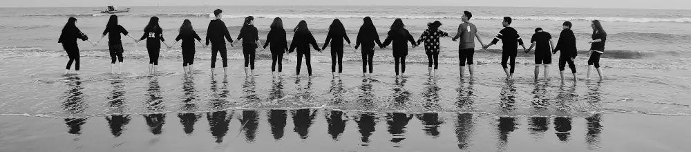 Group of people holding hands on a beach